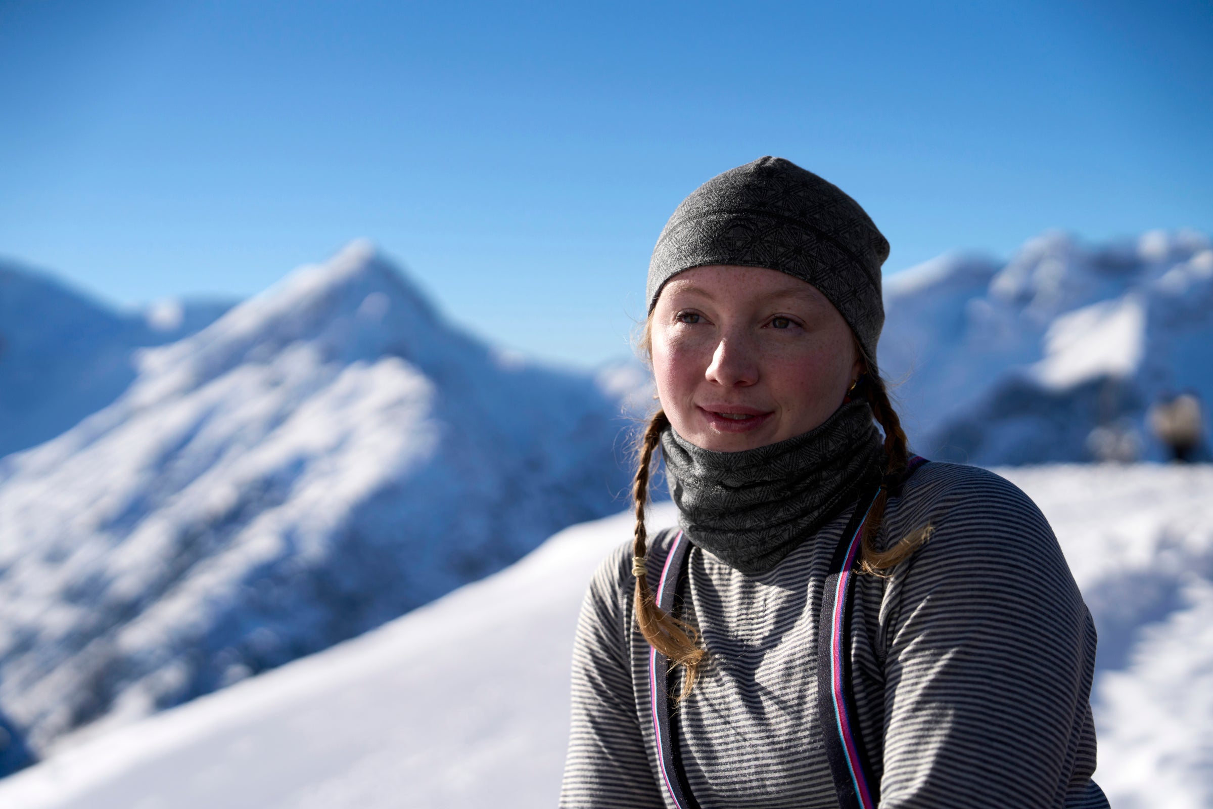 Person wearing a merino baselayer and neck warmer in snowy mountains