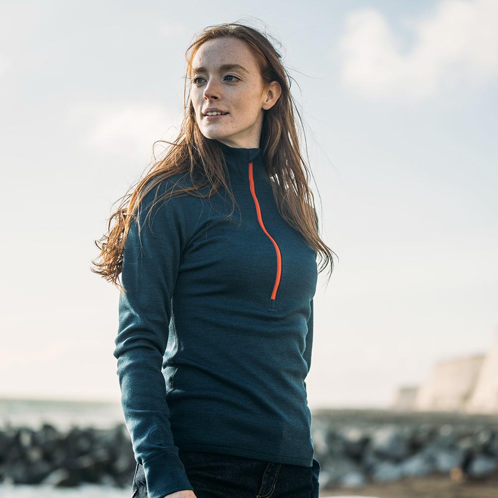 Isobaa | Womens Merino 320 Long Sleeve Half Zip (Petrol/Orange) | Conquer cold trails, blustery commutes, and unpredictable weather with the ultimate Merino wool half-zip top. | Model: Sophie